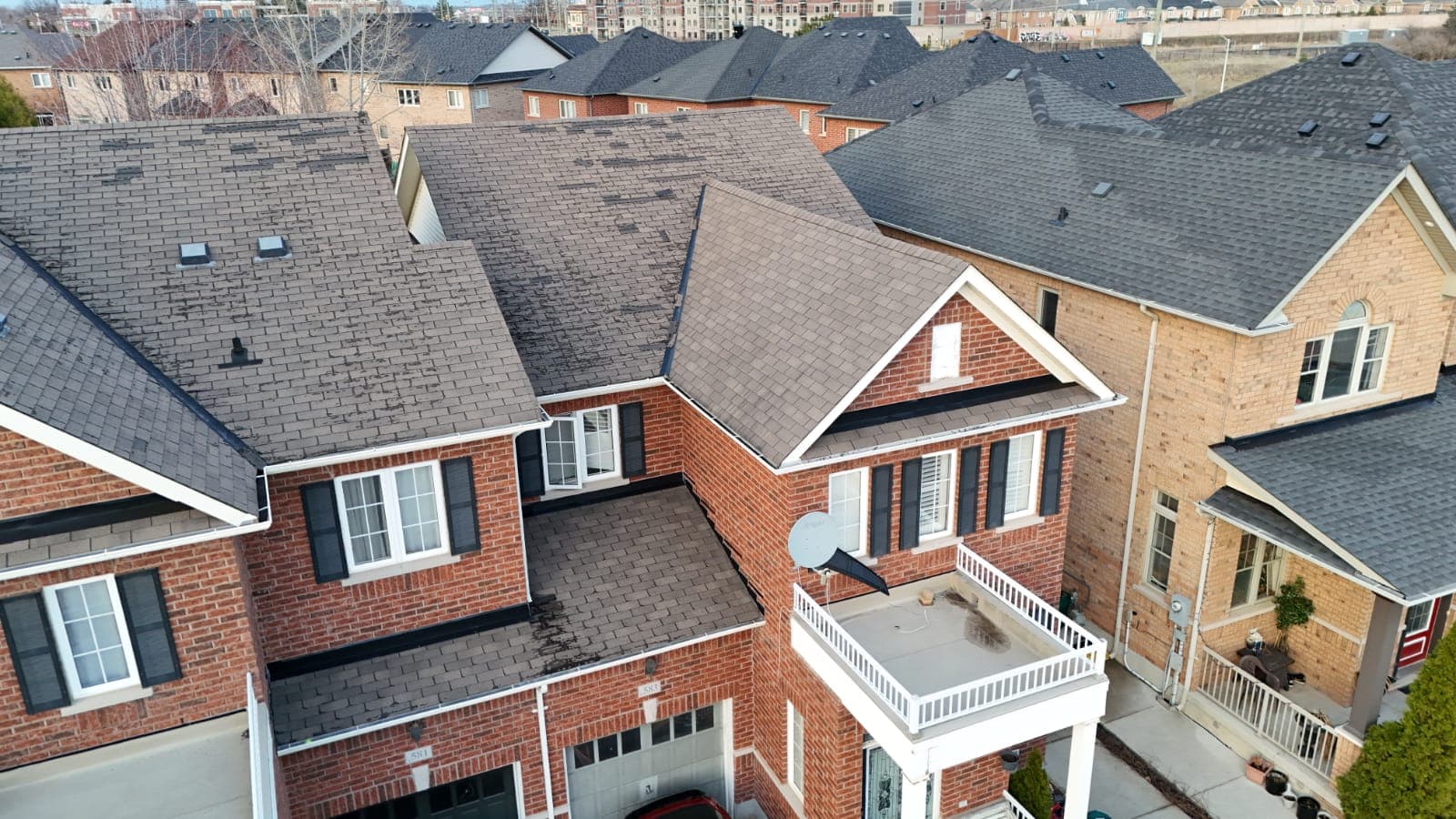 Drone photo showing storm and wind damage — lifted and missing shingles
